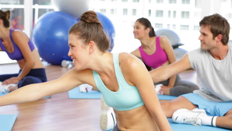 Fitness-class-sitting-together-and-stretching