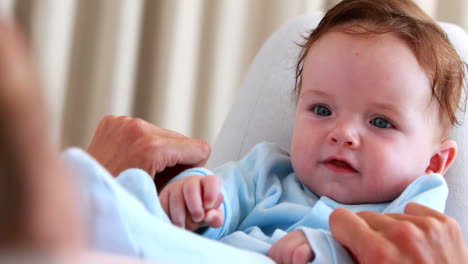 Baby-boy-in-blue-babygro-playing-with-mother