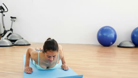 Fit-brunette-doing-yoga-on-exercise-mat