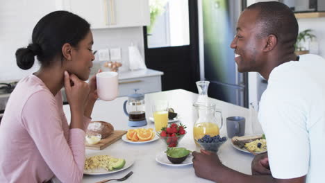 Ein-Vielfältiges-Paar-Genießt-Ein-Gemeinsames-Frühstück-Zu-Hause-In-Der-Küche