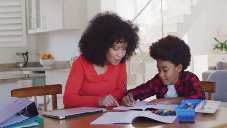 Mother-helping-son-with-homework-at-home