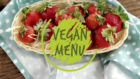 Animation-of-vegan-menu-text-over-strawberries-on-table
