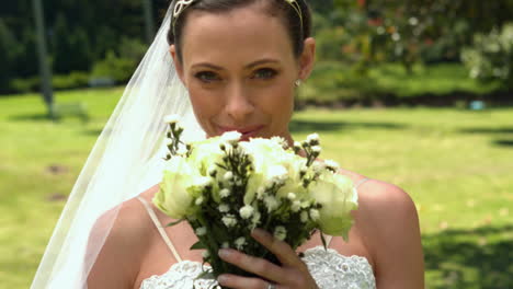 Braut-Riecht-Ihren-Blumenstrauß-Im-Park