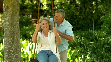 Senior-man-pushing-his-wife-on-a-swing