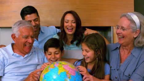 Extended-family-looking-at-globe-together-on-couch