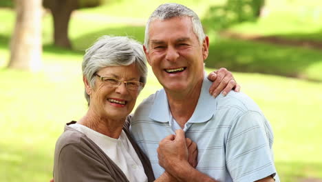 Retired-couple-in-the-park-hugging