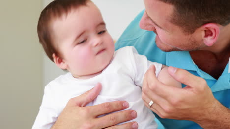 Smiling-father-tickling-his-baby-boy-