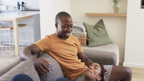 Una-Joven-Pareja-Afroamericana-Se-Relaja-En-Casa,-Tonos-Cálidos-En-Todas-Partes