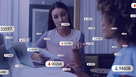 Animation-Von-Social-Media-Symbolen-Mit-Zahlen-über-Verschiedenen-Kollegen,-Die-Im-Büro-über-Die-Arbeit-Diskutieren