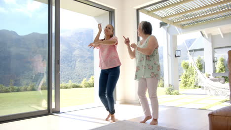 Abuela-Asiática-Y-Nieta-Birracial-Bailan-Juntas-En-Una-Habitación-Luminosa