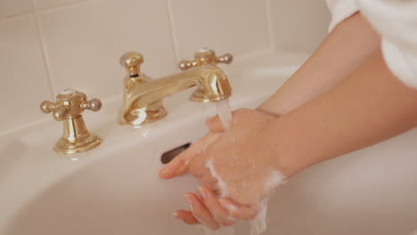 Woman-washing-her-hands-in-sink