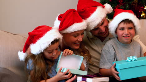 Glückliche-Junge-Familie-öffnen-Weihnachtsgeschenke-Auf-Der-Couch