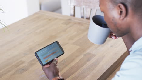 A-young-African-American-man-reviews-smart-home-app-energy-usage-on-a-tablet