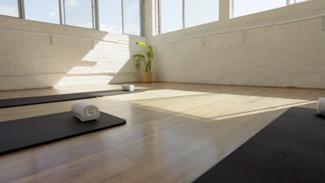 Sonnenlicht-Füllt-Friedliches-Yoga-Studio-Mit-Matten-Und-Handtüchern-Ordentlich-Platziert