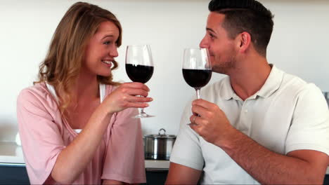 Happy-couple-having-red-wine-in-kitchen