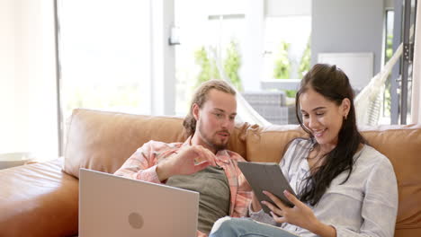 Una-Pareja-Diversa-Está-Usando-Una-Tableta-En-Un-Sofá-En-Casa