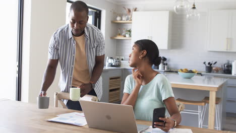 African-American-couple-is-focused-on-their-laptop-at-home,-paying-bills