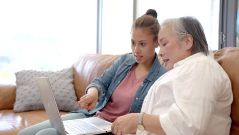 Biracial-Teenager-Zeigt-Laptop-Zu-Asiatischer-Großmutter-Zu-Hause