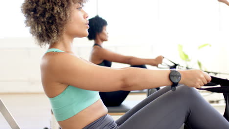 Biracial-young-woman-wearing-teal-top-practicing-pilates