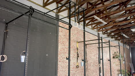 Gym-equipment-hanging-from-ceiling-in-a-room-with-brick-walls