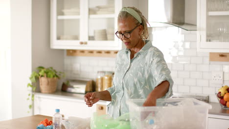 A-senior-African-American-woman-is-sorting-recycling-in-kitchen