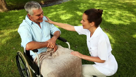 Nurse-talking-to-man-in-wheelchair-outside