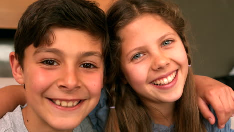 Siblings-smiling-at-camera