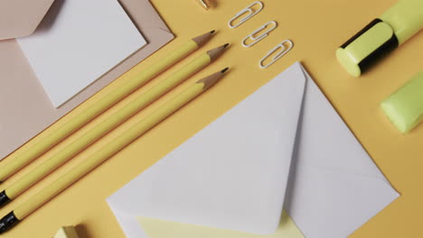 Bleistifte,-Büroklammern-Und-Umschläge-Sind-Ordentlich-Auf-Einer-Pastellgelben-Oberfläche-Angeordnet