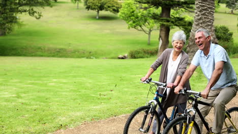 Retired-couple-in-the-park-riding-their-bikes