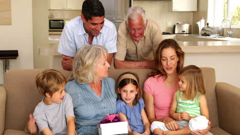 Abuela-Recibiendo-Regalos-De-Sus-Nietos-En-El-Sofá