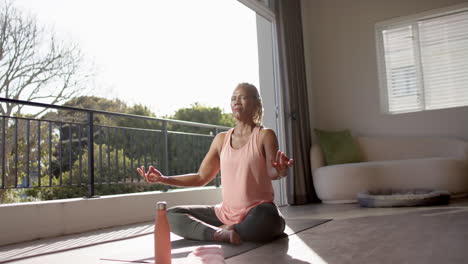 A-senior-African-American-woman-is-meditating-on-yoga-mat