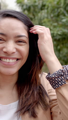 Vertical-video:-In-highschool,-young-woman-wearing-a-light-jacket-is-smiling