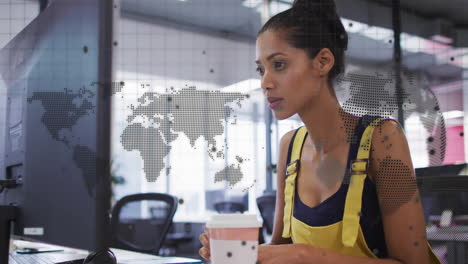 Animation-of-world-map,-globe-and-data-over-biracial-casual-businesswoman-using-computer-at-office