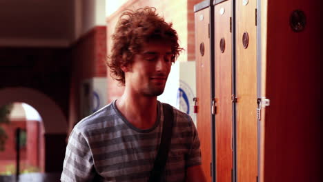 Student-walking-to-and-opening-his-locker