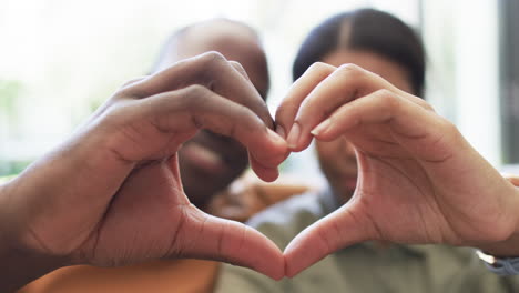 A-diverse-couple-forms-a-heart-shape-with-their-hands