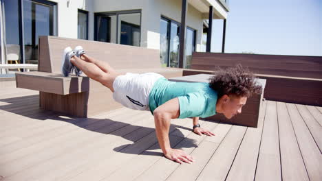 A-fit-biracial-man-is-doing-push-ups-on-a-bench-in-the-backyard-at-home