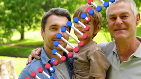 Animation-of-dna-strand-over-happy-caucasian-grandfather,-father-and-son-embracing-in-park
