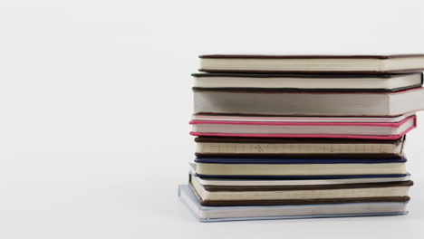 A-stack-of-hardcover-books-in-various-colors-leans-slightly-to-the-side,-with-copy-space