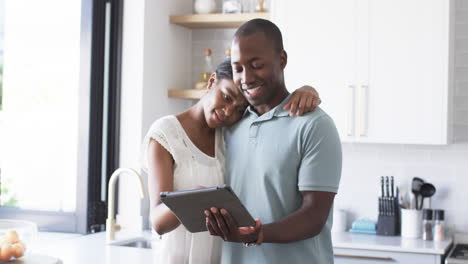 A-diverse-couple-is-using-a-tablet-in-the-kitchen-at-home