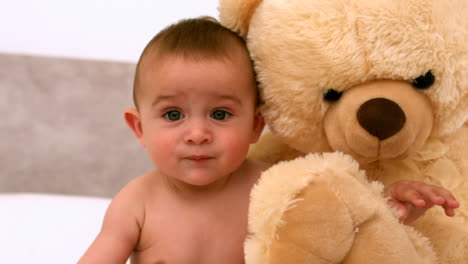 Süßes-Baby-Auf-Einem-Bett-Mit-Teddybär