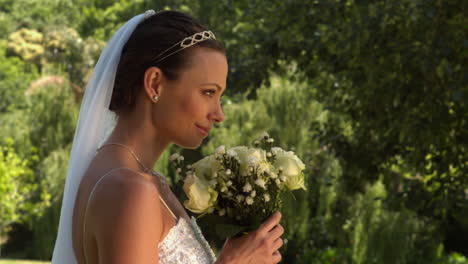 Bride-smelling-her-bouquet-in-the-park