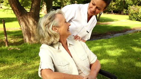 Nurse-talking-to-woman-in-wheelchair-outside