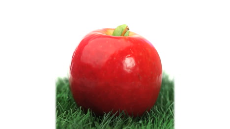 Roter-Apfel-Auf-Gras-Rotierend-