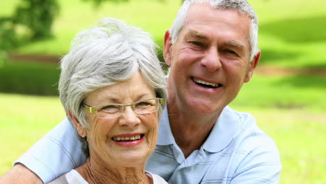 Affectionate-senior-couple-relaxing-in-the-park-