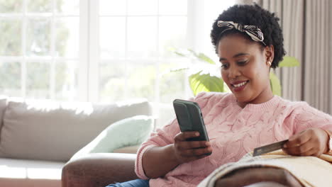 African-American-woman-smiles-while-using-her-smartphone-with-copy-space-at-home
