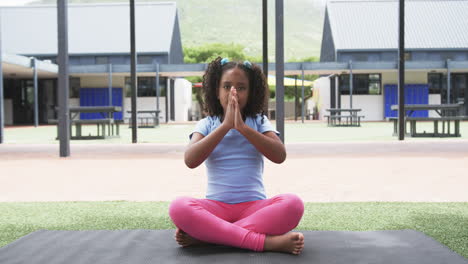 Biracial-girl-in-a-yoga-pose-at-a-school-playground