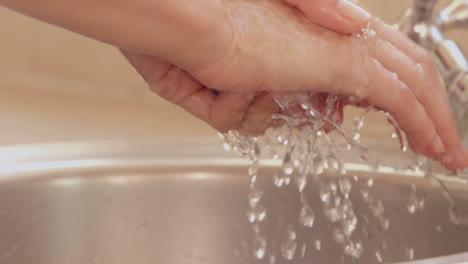 Woman-washing-her-hands-in-a-sink-