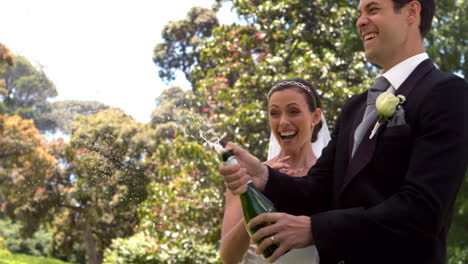 Groom-popping-bottle-of-champagne-with-new-wife