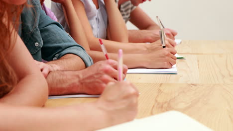 Students-sitting-in-class-taking-notes