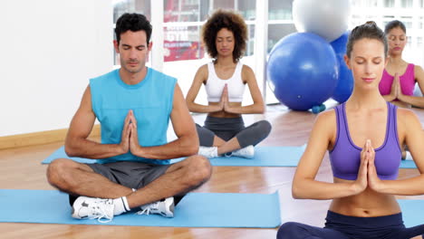 Yoga-class-sitting-in-lotus-pose-together